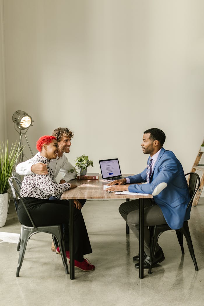 A professional financial advisor discusses options with a couple in a modern office setting.